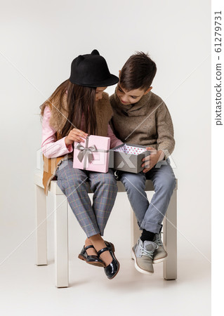 Cute stylish little couple child girl and boy sittting together . 61279731