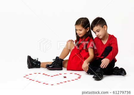 couple girl and boy make big heart shape out of small paper hearts 61279736