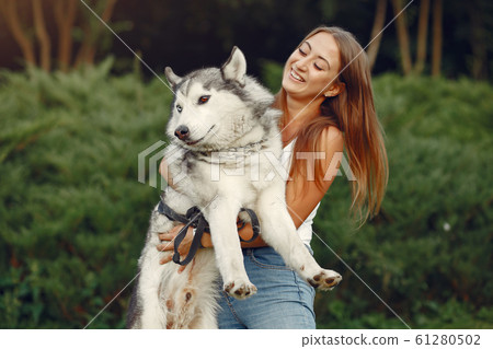 Girl in a spring park playing with cute dog Girl in a spring park playing with cute dog 61280502