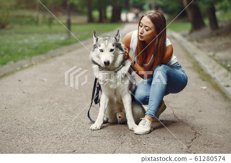 Girl in a spring park playing with cute dog Girl in a spring park playing with cute dog 61280574