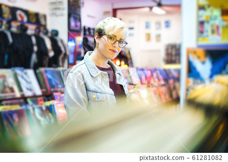 Young Woman Choosing Vintage Vinyl LP In Records Shop 61281082