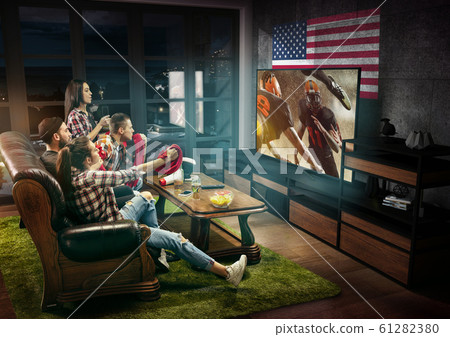 Group of friends watching TV, american football championship 61282380