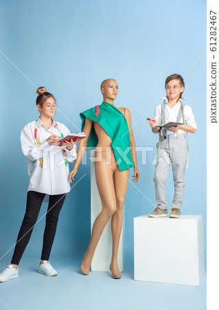 Little boy and girl dreaming about future profession of seamstress Little boy and girl dreaming about future profession of seamstress 61282467