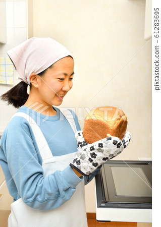女孩在廚房裡烤麵包 女孩在廚房裡烤麵包 61283695