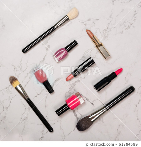 Flat lay of cosmetic products including lipsticks, nail varnish, makeup brushes Flat lay of cosmetic products including lipsticks, nail varnish, makeup brushes 61284589