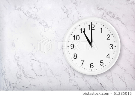 White round wall clock on white natural marble background 61285015
