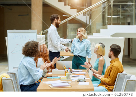 Handsome team leader congratulates designers 61290778