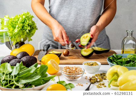 Woman preparing avocado for eating in the kitchen. cooking healthy food concept. 61298131