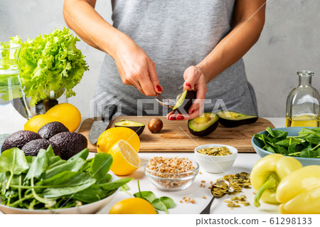 Woman preparing avocado for eating in the kitchen. cooking healthy food concept. 61298133