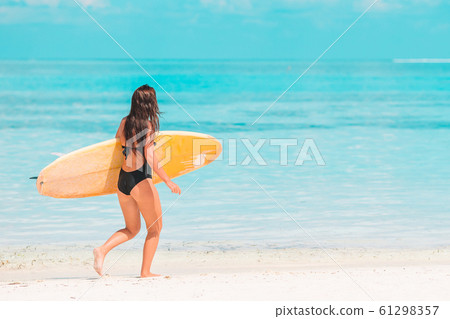 Beautiful surfer woman ready to surfing in turquoise sea, on stand up paddle board at exotic vacation 61298357