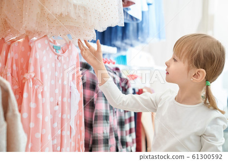 Funny girl looking at lovely pink dress in store 61300592