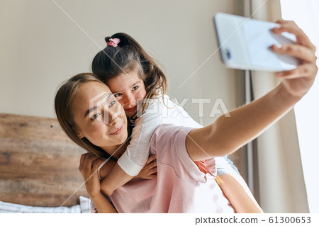 Cute young daughter on a piggyback ride 61300653