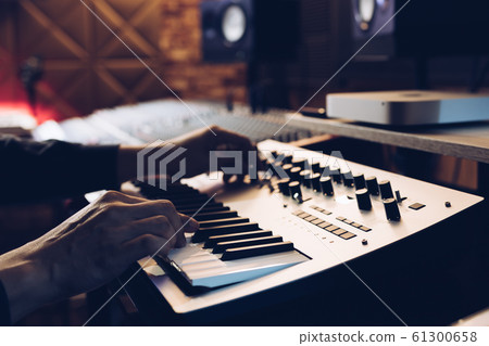 male musician hands playing keyboard synthesizer in recording studio male musician hands playing keyboard synthesizer in recording studio 61300658