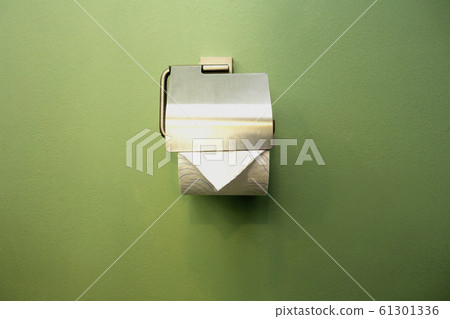 Close-up of toilet roll holder in bathroom near green wall Close-up of toilet roll holder in bathroom near green wall 61301336