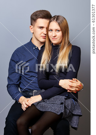 The guy put girl on his lap for a photoshoot. The guy put girl on his lap for a photoshoot. 61301377