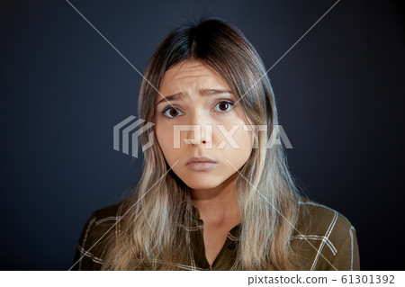 Upset look of a young woman watching television. Upset look of a young woman watching television. 61301392