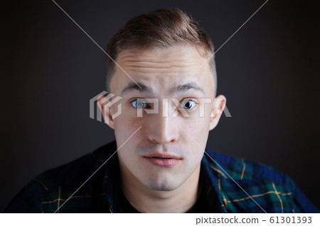 Wide eyes of a man watching the movie. Wide eyes of a man watching the movie. 61301393