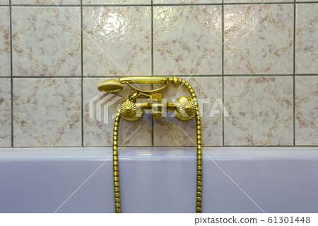 Vintage gold bathtub faucet and ceramic tiles in background.Retro bronze look. antique design Vintage gold bathtub faucet and ceramic tiles in background.Retro bronze look. antique design 61301448