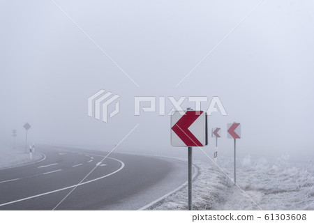 Warning road signs before dangerous curve in dense Warning road signs before dangerous curve in dense 61303608