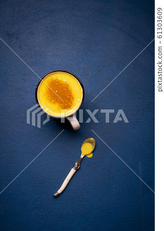 Turmeric latte on a blue table. Healthy drink. Turmeric latte on a blue table. Healthy drink. 61303609