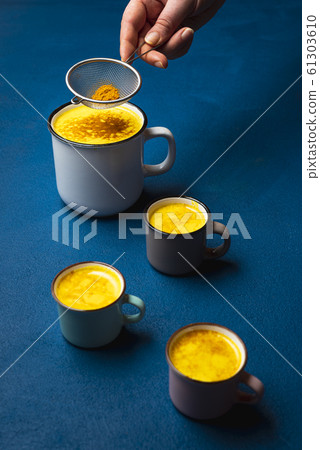 Turmeric latte in cup and spice powder. Warm detox Turmeric latte in cup and spice powder. Warm detox 61303610