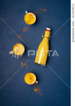 Turmeric latte in bottle and cups with spice Turmeric latte in bottle and cups with spice 61303611