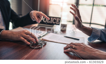 suspect with handcuffs being interviewed in suspect with handcuffs being interviewed in 61303829