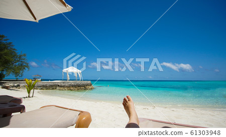 Feet tourist relax at Maldives turquoise sea white sand tropical beach paeadise destinaton Feet tourist relax at Maldives turquoise sea white sand tropical beach paeadise destinaton 61303948