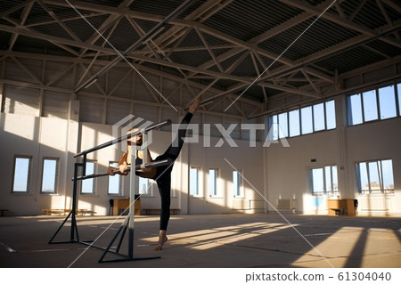 Flexible little girl gymnast doing acrobatic exercise in gym Flexible little girl gymnast doing acrobatic exercise in gym 61304040