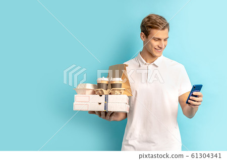 smiling positive delivery man with smartphone smiling positive delivery man with smartphone 61304341