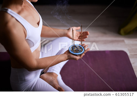 Yoga woman using aroma sticks 61305517