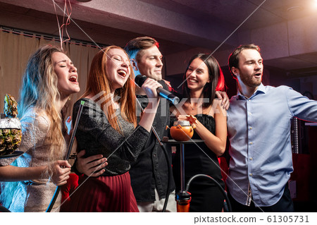 group of young people rocking in karaoke bar 61305731