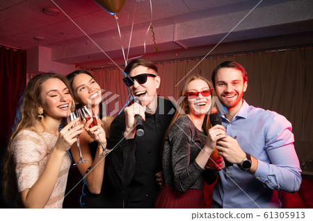 Young caucasian people dance and sing in karaoke club 61305913