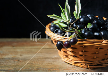 A wiker basket full with ripe fresh black olives from Puglia, Italy, low key 61306000