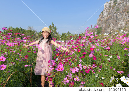 Happy cute asian girl smile in cosmos garden 61306113