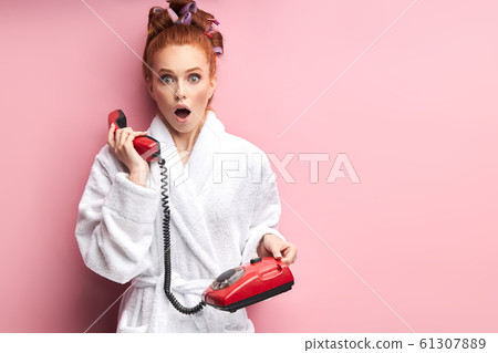Portrait of beautiful young redhead girl wearing bathrobe stand talking on landline phone Portrait of beautiful young redhead girl wearing bathrobe stand talking on landline phone 61307889