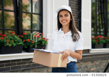 Crop of deliverywoman holding parcel and folder. Crop of deliverywoman holding parcel and folder. 61308828