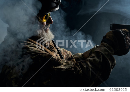 Military veteran pointing with gun. Military veteran pointing with gun. 61308925