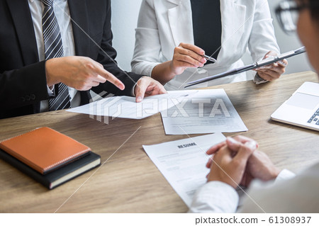 Employer or committee holding reading a resume 61308937