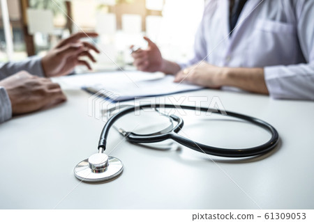 Doctor consulting with patient and checking 61309053
