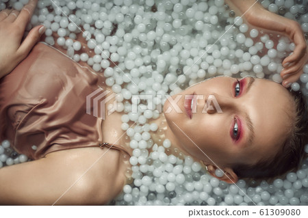 Blonde woman posing in water with balls. Blonde woman posing in water with balls. 61309080