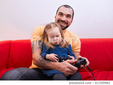 cheerful father and daughter sit playing video game cheerful father and daughter sit playing video game 61309962