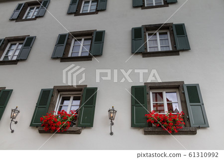 Wall with wooden windows and flower pots on a Wall with wooden windows and flower pots on a 61310992