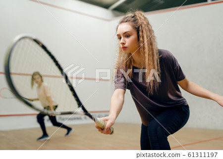 Two players with squash racket playing on court 61311197