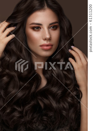 Beautiful brunette model: curls, classic makeup and full lips. The beauty face. 61311200
