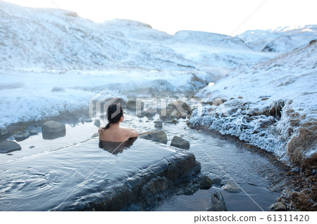 The girl bathes in a hot spring in the open air The girl bathes in a hot spring in the open air 61311420