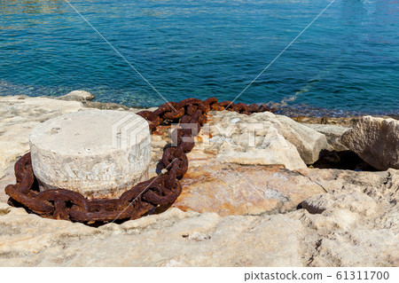 A metal chain attached to the bollard at port 61311700