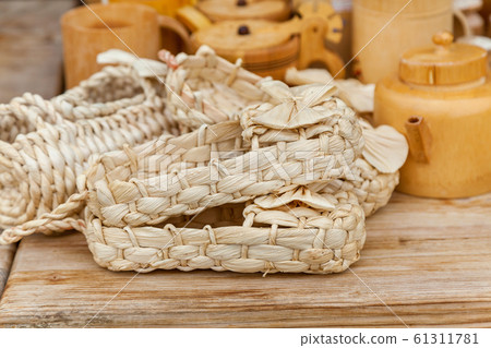 Many pairs of bast shoes on the wooden table for 61311781