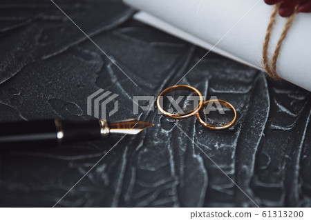 Two broken golden wedding rings divorce decree document. Divorce and separation concept Two broken golden wedding rings divorce decree document. Divorce and separation concept 61313200
