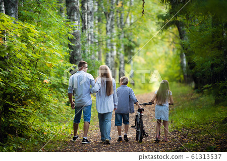 Happy family outdoors spending time together. Father, mother, daughter and son are having fun in a summer park at summer Happy family outdoors spending time together. Father, mother, daughter and son are having fun in a summer park at summer 61313537